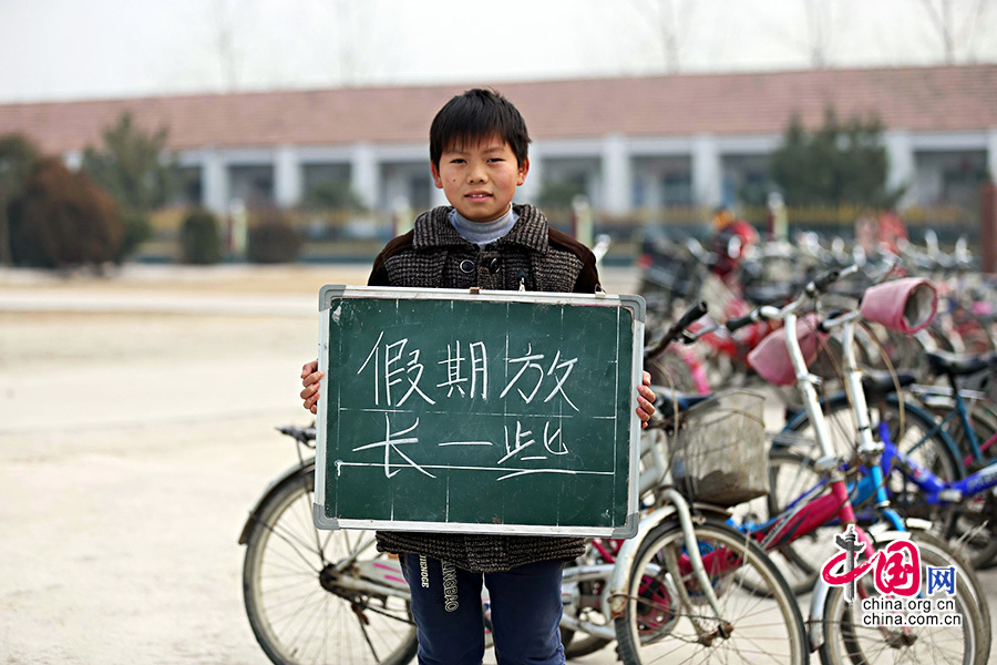 2013年1月14日，安徽省蚌埠市固鎮縣清涼小學，六年級學生在寒假即將來臨前，展示寒冬裏的假期心願。圖為張浪，寒假願望是假期放長一些。