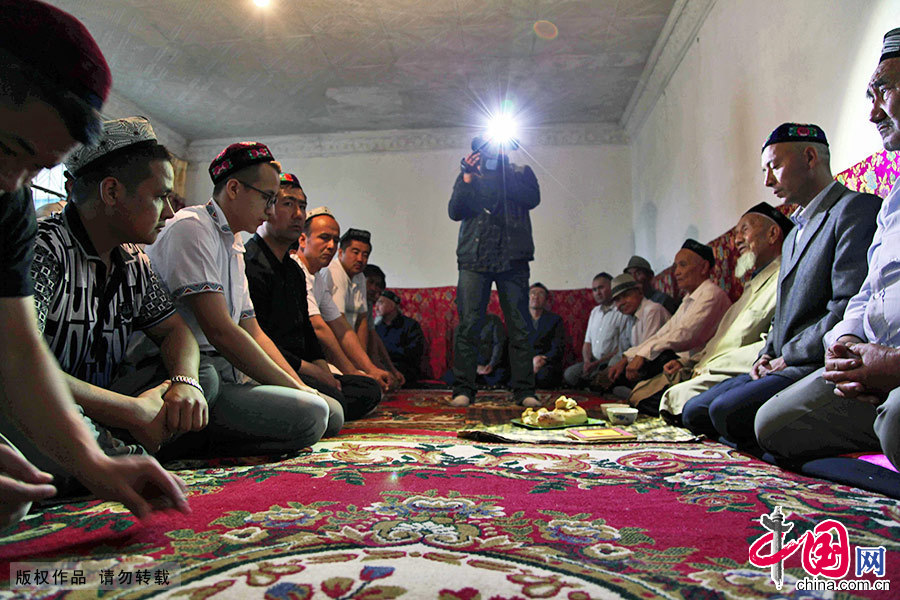  在重大节日时，维吾尔族大多数人都会戴花帽。这是一位维吾尔族小伙的婚礼，阿訇先要念古兰经，参加的人员一般都戴花帽。中国网图片库 孙继虎/摄