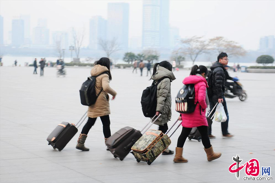  2014年1月16日，南京火車站，幾位大學生拖著行李從站前廣場轉中央門長途汽車站。當天，是2014年全國春運第一天。 中國網圖片庫 楊素平攝影