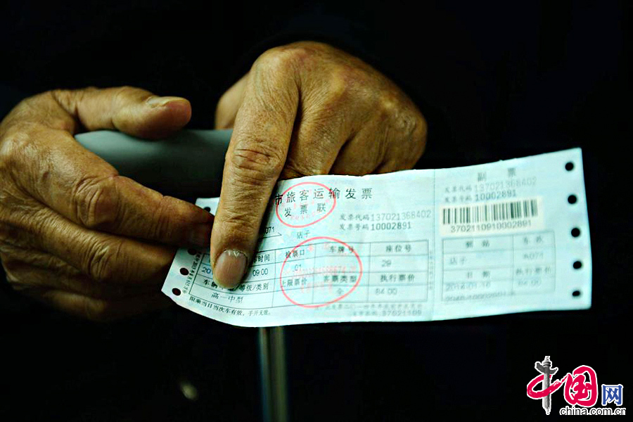 2014年1月16日，山東省青島市黃島汽車總站一位殘疾老人手持車票等候乘車。中國網圖片庫俞方平攝影