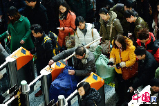 2014年01月16日，浙江省杭州市，在铁路杭州东站的候车大厅，旅客通过自动检票机。 中国网图片库 龙巍 摄