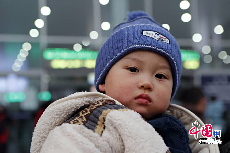 一岁的多多，跟着父母第一次乘火车回湖南。显然还没有睡醒的他面对记者的镜头有些发呆。