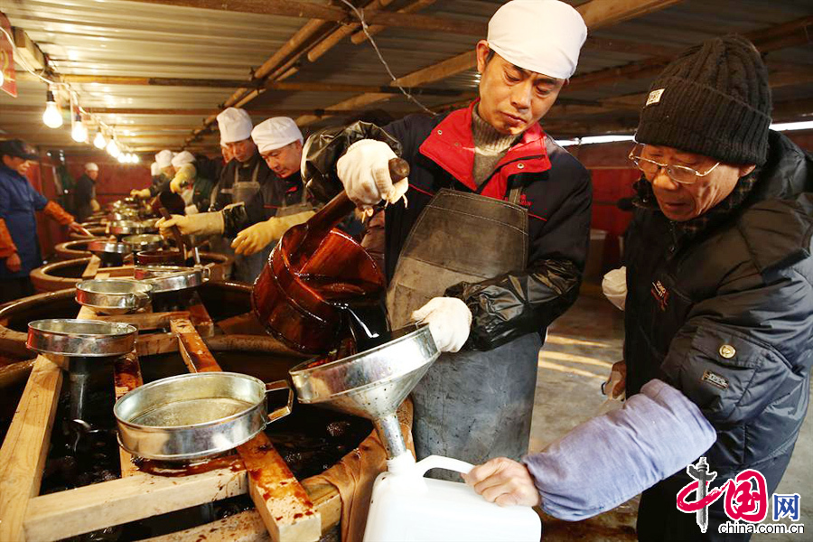 1月17日，工作人员在为市民打酱油。 中国网图片库杨雨摄影