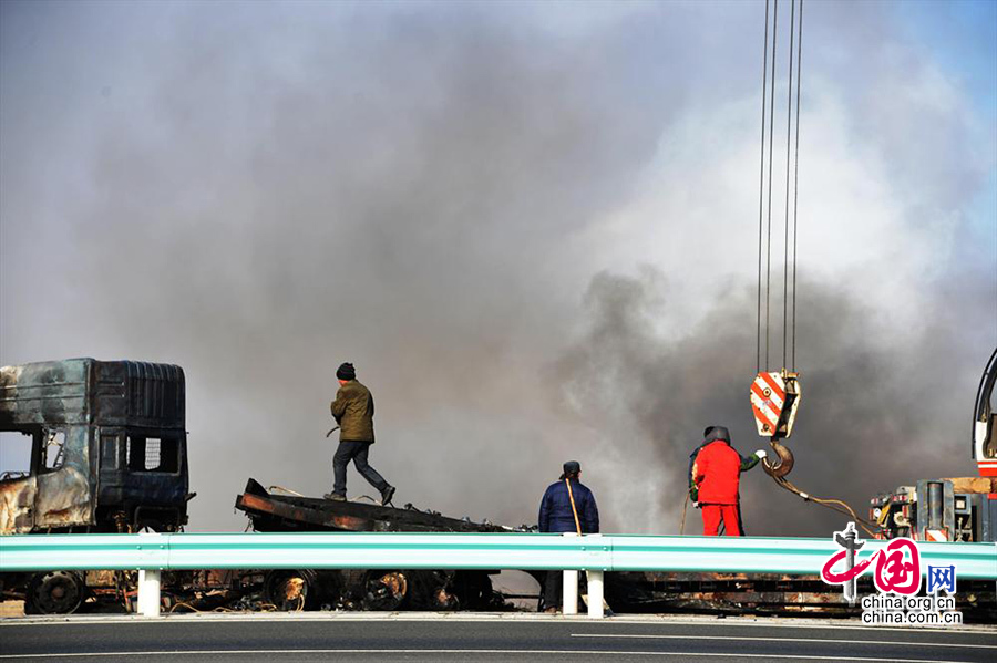 2014年01月18日，312国道新疆吐鲁番地区鄯善县境内发生的车祸现场，救援人员在清理现场。