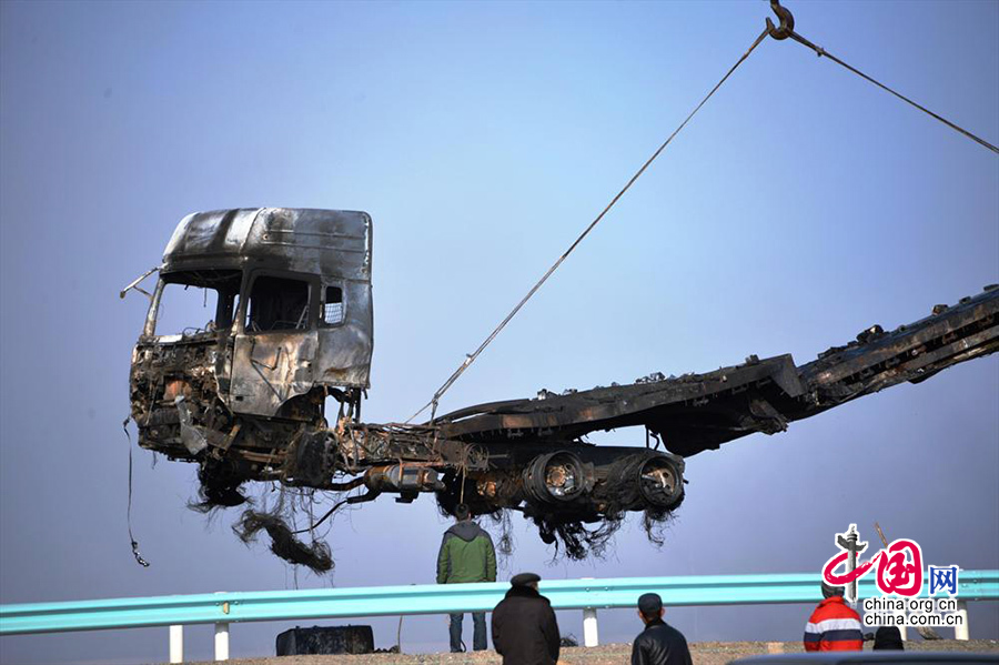 2014年01月18日，312国道新疆吐鲁番地区鄯善县境内发生的车祸现场，救援人员用大型机械清理被焚毁货车。