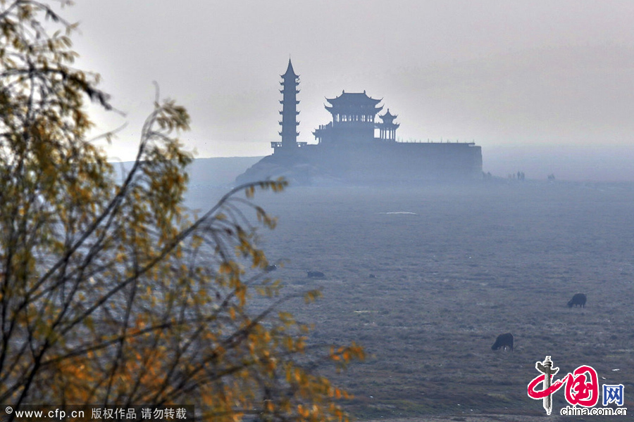 2014年01月19日，江西省九江市，鄱陽湖江西省星子縣水域，湖心標誌性景觀落星墩“水落石出”，人們在落星墩附近遊玩。 圖片來源：CFP