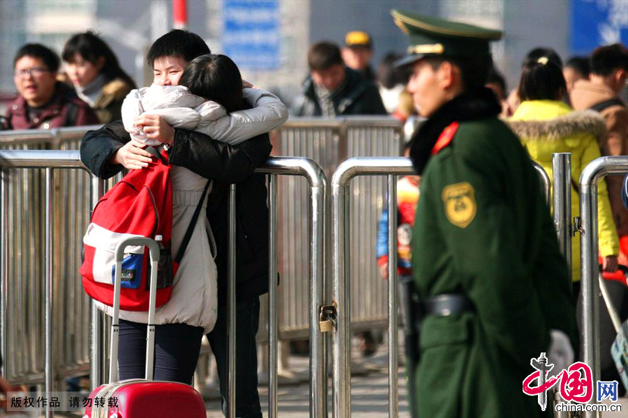1月15日，一对情侣隔着火车站栅栏拥抱依依惜别。中国网图片库 颜闽航/摄