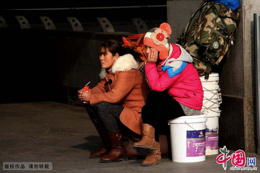 1月16日，南京火车站，旅客坐在行李上等候同伴。中国网图片库 王胜涛/摄