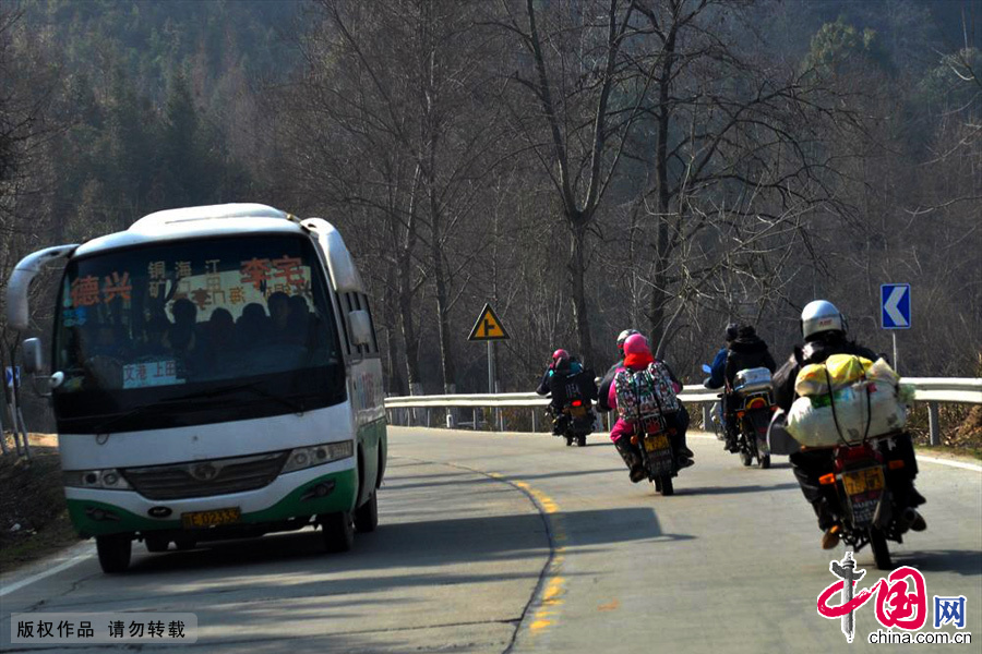 1月19日，江西返乡农民工骑摩托车行驶在德兴市泗州镇路段，与对侧车道中巴会车通过。中国网图片库 胡敦煌/摄