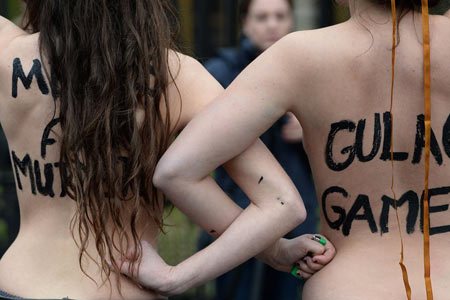 当地时间2014年2月7日，德国柏林，裸露上身的女权组织成员在俄罗斯驻德大使馆外示威。当天是索契冬奥会开幕日，该组织试图通过此举对俄总统普京的同性恋政策表示抗议。