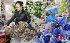 014年02月11日，浙江省临安市一家花店的工作人员在包装玫瑰花。中国网图片库 胡剑欢 摄 