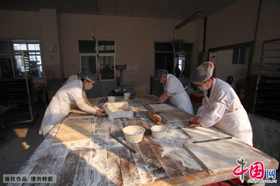 元宵馅料生产车间，工作人员将成型的馅料切割成一个个小块。中国网图片库吕斌/摄