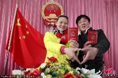 结婚证，2014年2月14日，在江苏省赣榆县民政局婚姻登记处，一对新人手持结婚证拍照留念。 