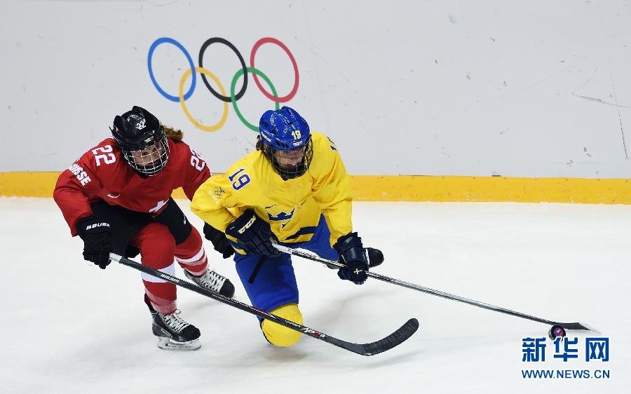 2月20日，瑞士队球员阿尔特曼（左）与瑞典队球员林德拼抢。当日，在2014索契冬奥会女子冰球铜牌赛中，瑞士队对阵瑞典队。