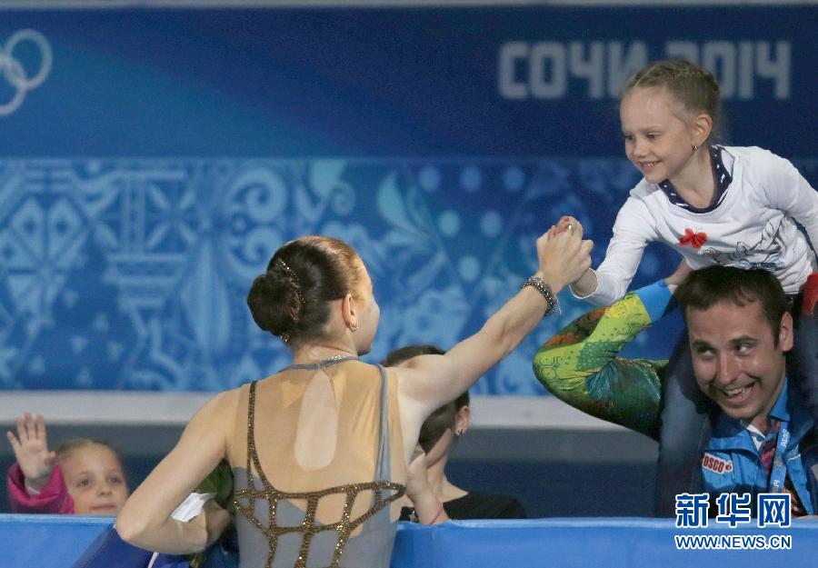 2月20日，俄罗斯选手斯托尼科娃（前）夺冠后与小朋友握手致意。当日，在2014年索契冬奥会花样滑冰女子单人滑比赛中，俄罗斯选手斯托尼科娃以224.59分的成绩夺得冠军。
