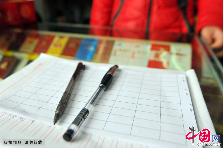 櫃檯上的紙和筆是姐妹兩每天必須要準備工具，對於他們的便利店來説這樣普通的工具卻發揮著重要的作用。中國網圖片庫 葛傳紅/攝
