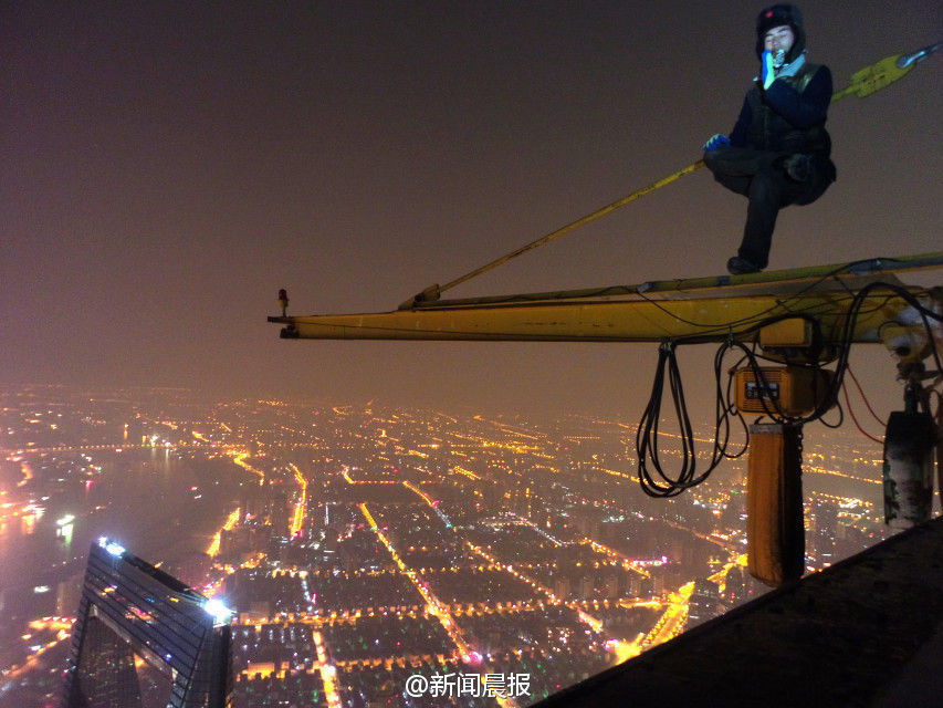 图为两90后小伙夜爬上海中心大厦。