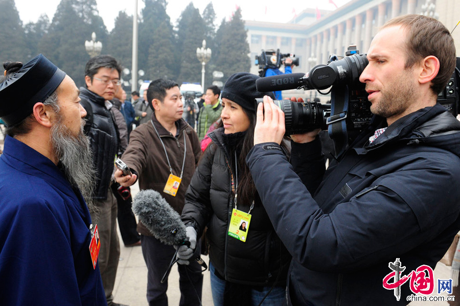 2014年03月03日，北京，2014全國政協十二屆二次會議開幕，媒體記者眾生相。圖為一家外媒記者在採訪中。 圖片來源：CFP