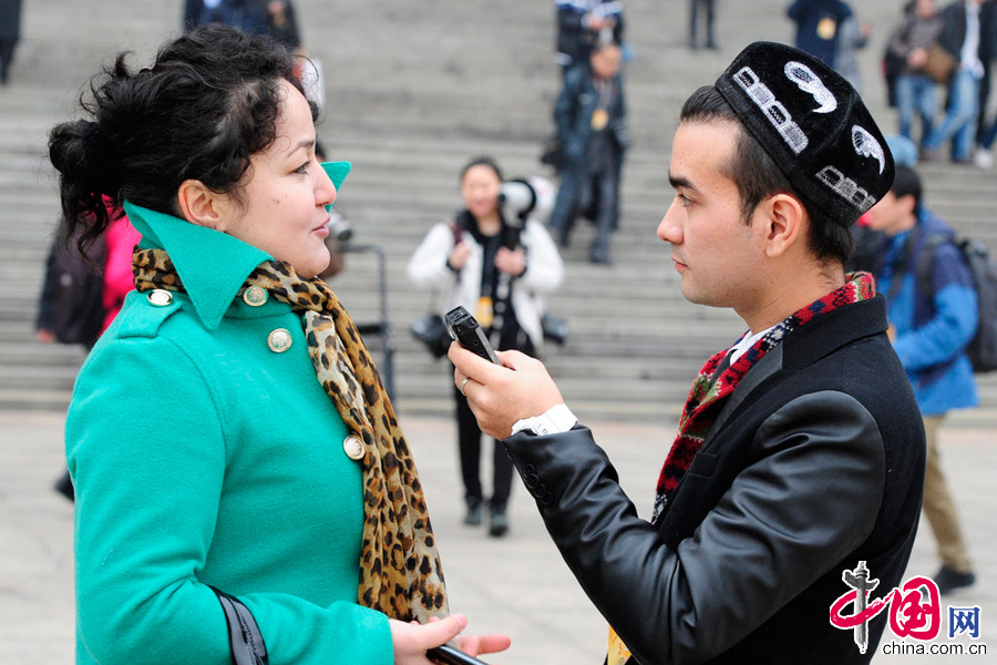  2014年03月03日，北京，2014全國政協十二屆二次會議開幕，媒體記者眾生相。圖為一家來自新疆的媒體記者在採訪委員中。 圖片來源：CFP