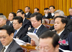 全国政协委员周明伟（中）听取《政府工作报告》。