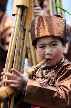 广西三江侗族自治县“百家宴”上，一名侗族小朋友在吹奏芦笙欢迎宾客。