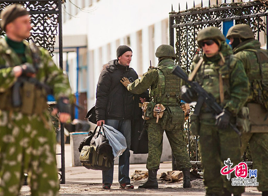当地时间2014年3月19日，乌克兰海军位于克里米亚塞瓦斯托波尔市的总部被占领，乌克兰海军官兵被迫撤离基地。图为被迫离开的乌克兰海军官兵在出大门时被搜身。