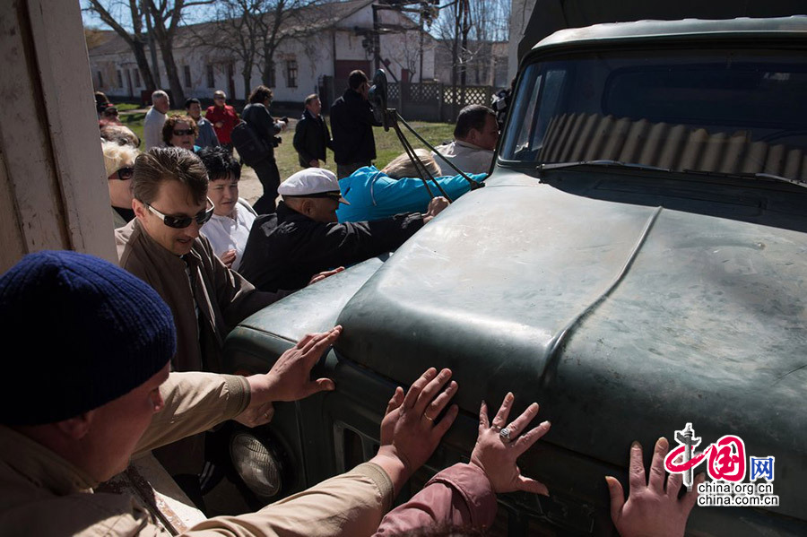 当地时间2014年3月22日，克里米亚西部新费奥多罗夫卡，约200名亲俄示威者冲入当地的乌克兰空军基地，摘下乌克兰国旗。乌克兰士兵被迫离开。