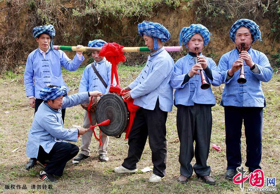  布依族代表队演奏“布依铜鼓十二调”，展示服饰和乐器。“布依铜鼓十二调”，即铜鼓演奏的十二段乐曲。铜鼓是我国古代南方少数民族世代相传的特殊乐器,布依族是使用铜鼓的主要民族之一。中国网图片库 卢维/摄