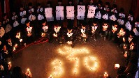 江苏省金山中等专业学校礼堂中，学生们聚集在一起，点燃蜡烛，为马航失联客机MH370上的生命默哀