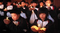 江苏省金山中等专业学校礼堂中，学生们聚集在一起，点燃蜡烛，为马航失联客机MH370上的生命默哀4