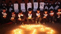 江蘇省金山中等專業學校禮堂中，學生們聚集在一起，點燃蠟燭，為馬航失聯客機MH370上的生命默哀6
