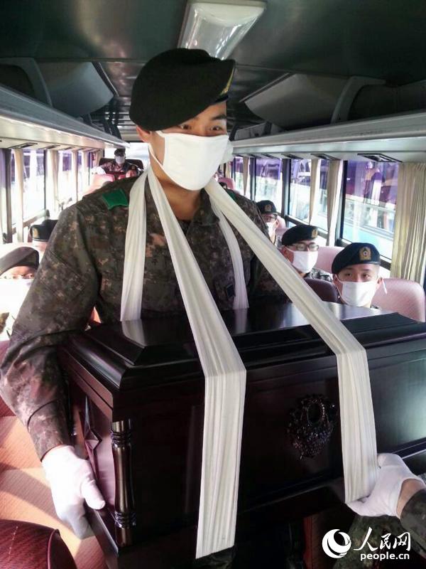 圖為南韓軍人手捧棺木。（人民網 張悅攝）