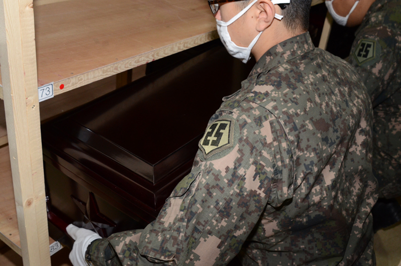 圖為南韓軍人從架子上搬出棺木。（人民網 張悅攝）