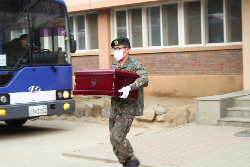 圖為一名南韓軍人在搬運棺木。（人民網 黃海燕攝）