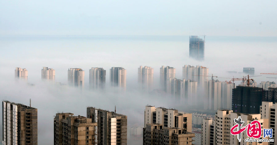  2014年4月2日在山东日照市新市区拍摄的平流雾景观。当日，山东日照市区出现平流雾景观，建筑在雾中若隐若现，宛如人间仙境。平流雾是暖湿空气移到较冷的陆地或水面时，因下部冷却而形成的雾。 中国网图片库 李晓龙摄影
