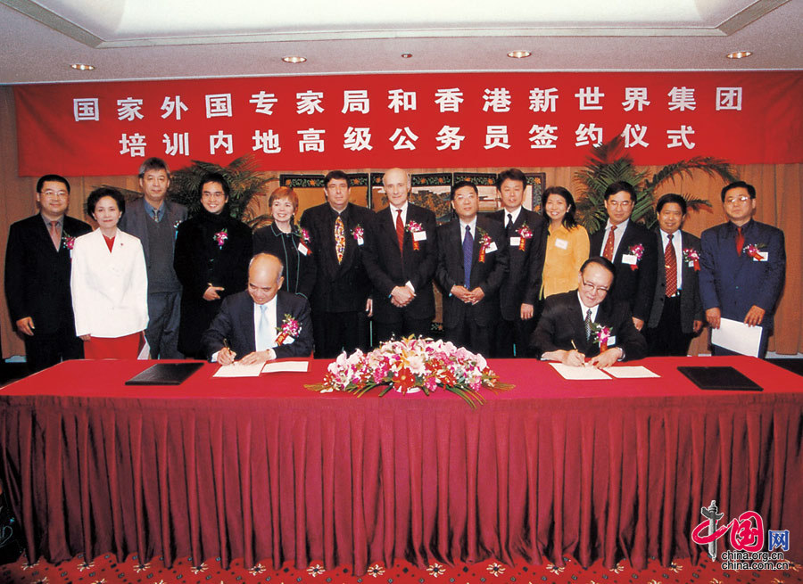  2004年，国家外国专家局和香港新世界集团举行合作培训内地高级公务员续签协议仪式，万学远（右）和新世界集团董事、总经理郑家纯代表双方签字。
