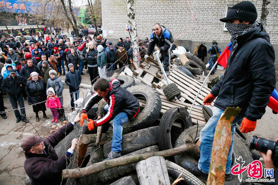 当地时间2014年4月12日，乌克兰东部城市Slaviansk，武装人员占领当地警察大楼。据悉，至少15名武装人员参与的占领行动.图片来源:CFP