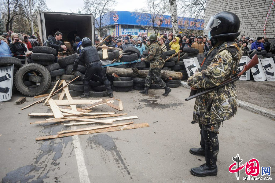 当地时间2014年4月12日，乌克兰东部城市Slaviansk，武装人员占领当地警察大楼。据悉，至少15名武装人员参与的占领行动.图片来源:CFP