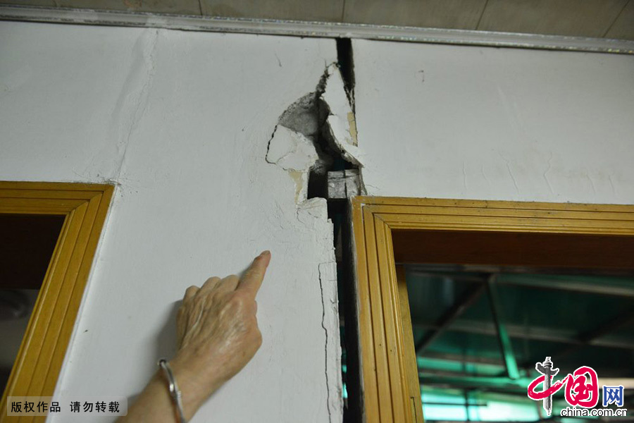 　2014年04月16日，浙江省杭州市，杭州翠苑三区9幢1单元102室的居民指着自家开裂的墙体。中国网图片库 龙巍摄