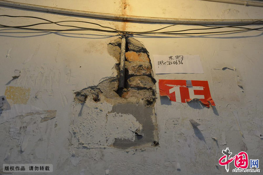 　2014年04月16日，浙江省杭州市，杭州翠苑三區9幢1單元102室的居民指著自家開裂的墻體。中國網圖片庫 龍巍攝