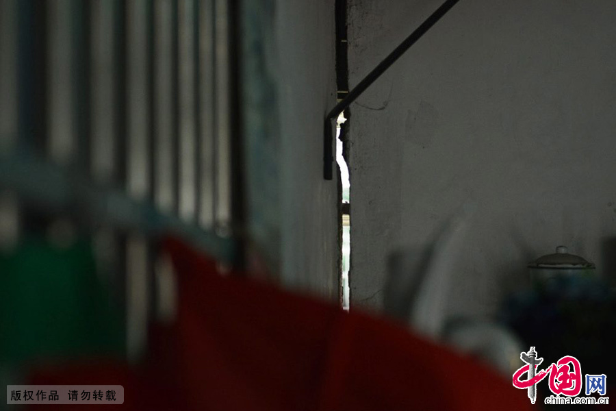 　2014年04月16日，浙江省杭州市，杭州翠苑三区9幢1单元102室的居民指着自家开裂的墙体。中国网图片库 龙巍摄