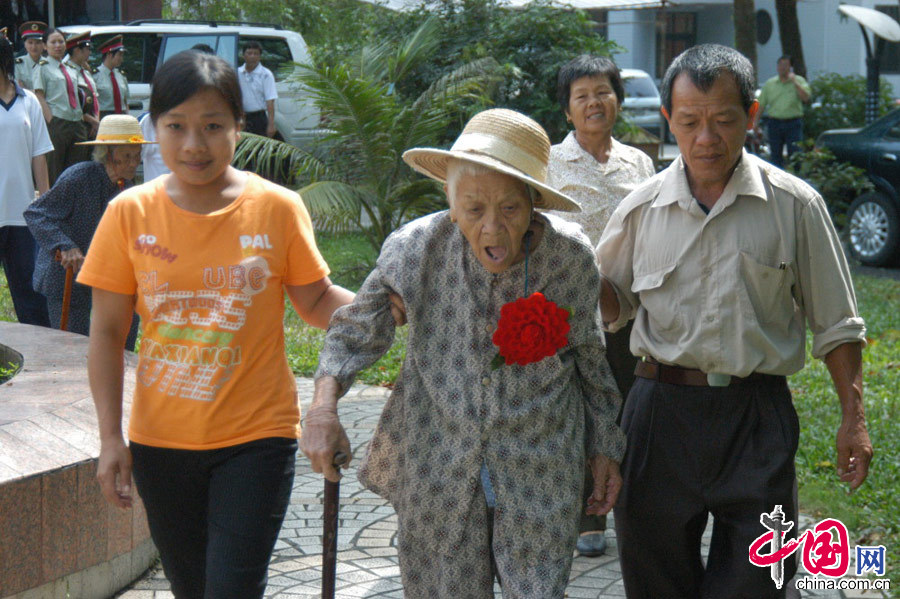 海南瓊海，盧業(yè)香在親人攙扶下出席紅色娘子軍75周年紀念活動（圖為2006年4月30日拍攝）。 中國網(wǎng)圖片庫 蒙鐘德供圖