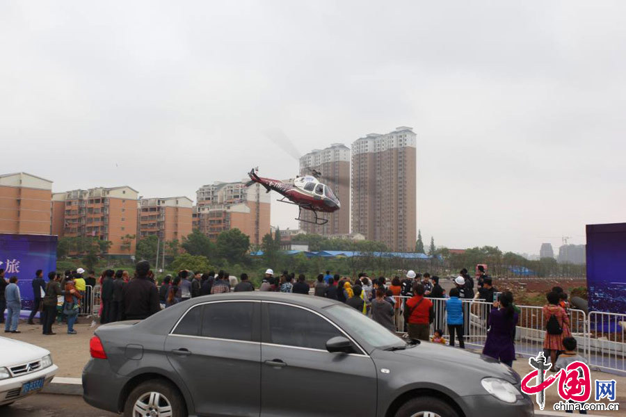  2013年4月20日，江西省九江市某楼盘附近，一架B—7792型直升机不停起降，搭载购房者从空中观赏九江市区美景。 中国网图片库 魏东升摄影