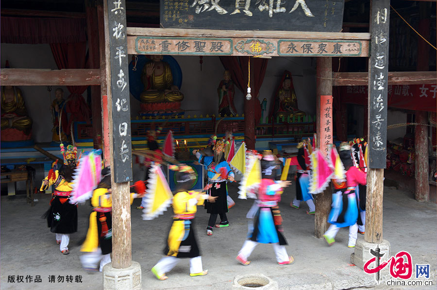 女子傩戏队的成员们一袭青纱罩面，头顶将军面具，插战旗、持刀枪，随锣鼓、舞打唱，演绎着中国古代英雄的铿锵战歌。