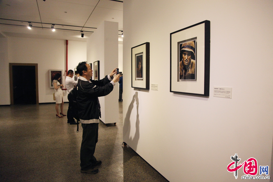  4月25日，一名參觀者在“攝影改變世界”——美國喬治·伊斯曼國際攝影和電影博物館影像收藏展及喬治·伊斯曼生平展上拍攝展出的攝影作品。 中國網記者 李佳攝影