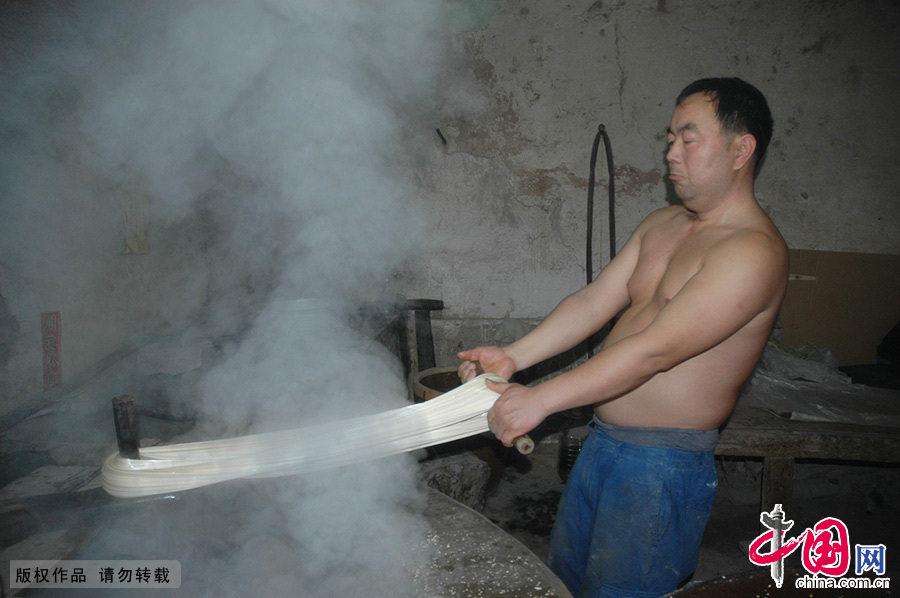 在40度的高温下，工匠们汗流浃背，手握着滚烫的糖稀进行手工拨糖。
