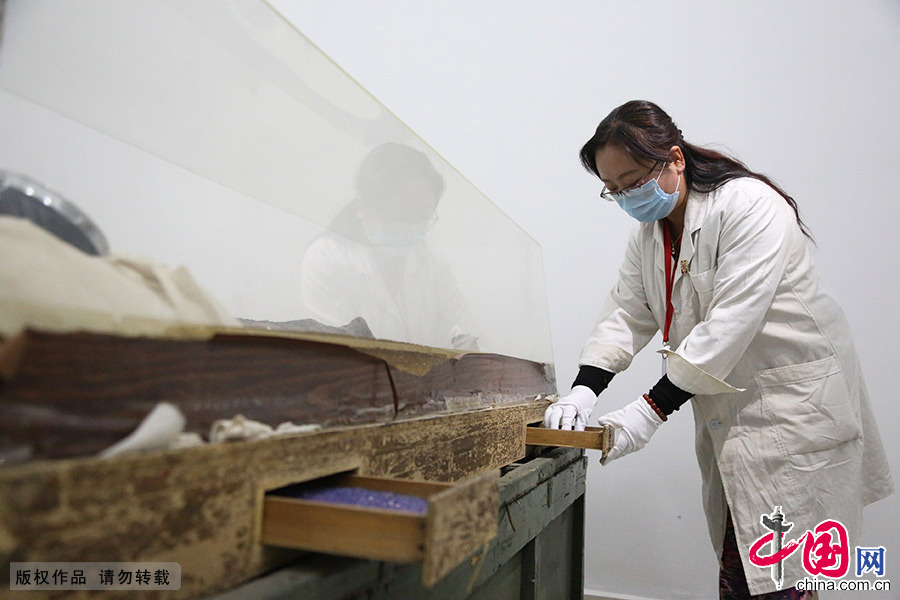藏品管理员包龙梅在契丹女尸库房进行防潮药品的更换。