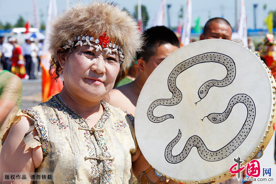 手拿鱼皮鼓的赫哲人。渔猎生活给赫哲族人服饰打上特别印记
