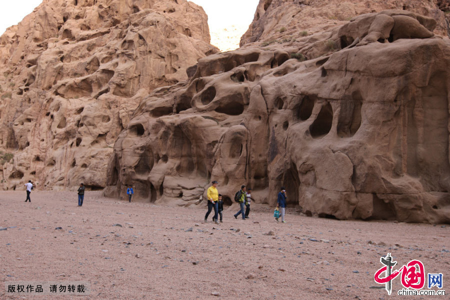 遊客在新疆哈密泥岩和沙岩構成“野人谷”遊玩。