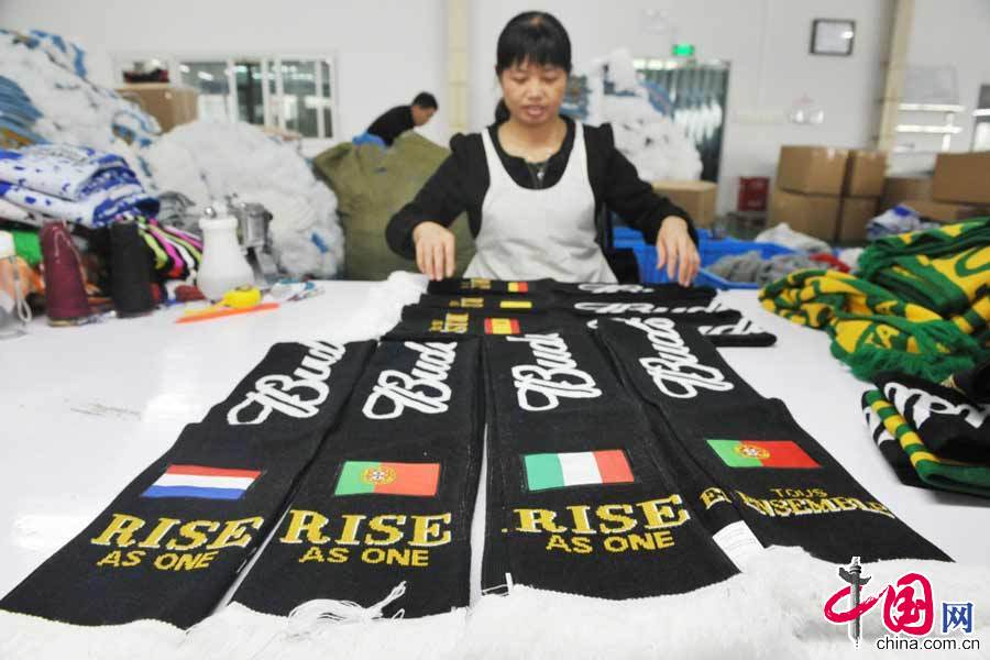  4月26日，位於浙江省臨安市玲瓏工業功能區內的某公司的工人正在對出口國外的巴西世界盃球迷圍巾進行成品檢查。 中國網圖片庫 胡劍歡攝影